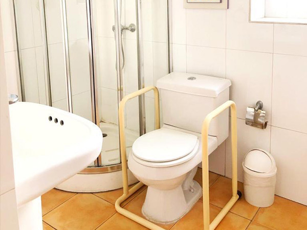 Baño adaptado de Residencia Los Andes con ducha, barras de apoyo y elementos de seguridad