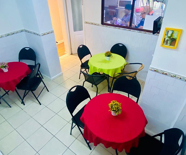 Comedor luminoso de la residencia con mesas redondas para compartir las comidas