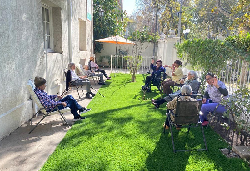 Residentes de Los Andes disfrutando del jardín con pasto verde en un día soleado